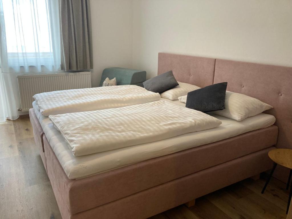 a bed with two pillows on it in a room at Bee happy Haus Burböck in Flachau