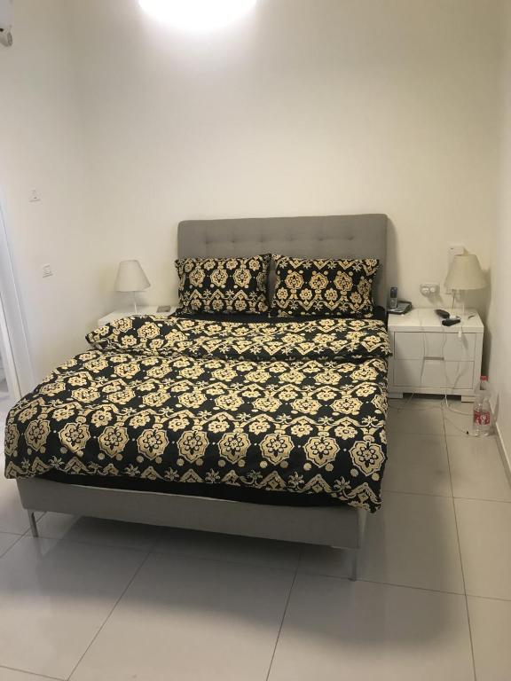 a bedroom with a bed with a black and white comforter at Schöne zimmer in der city tel-aviv in Karkom