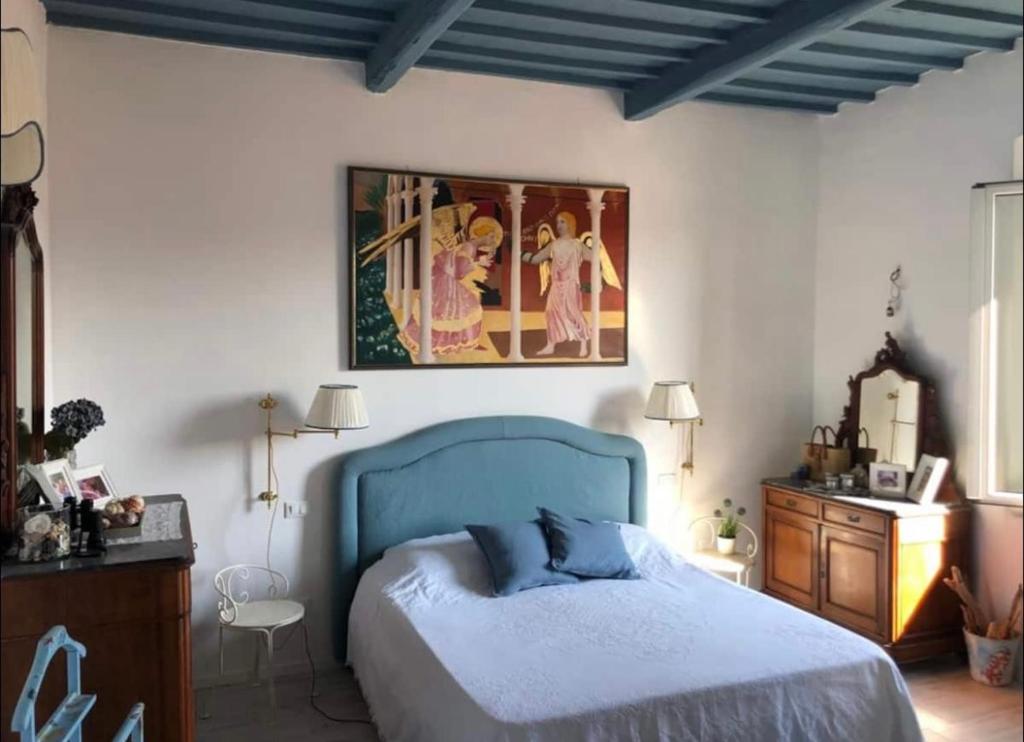 ein Schlafzimmer mit einem blauen Bett und einem Gemälde an der Wand in der Unterkunft La Casa di Nemo in Piombino