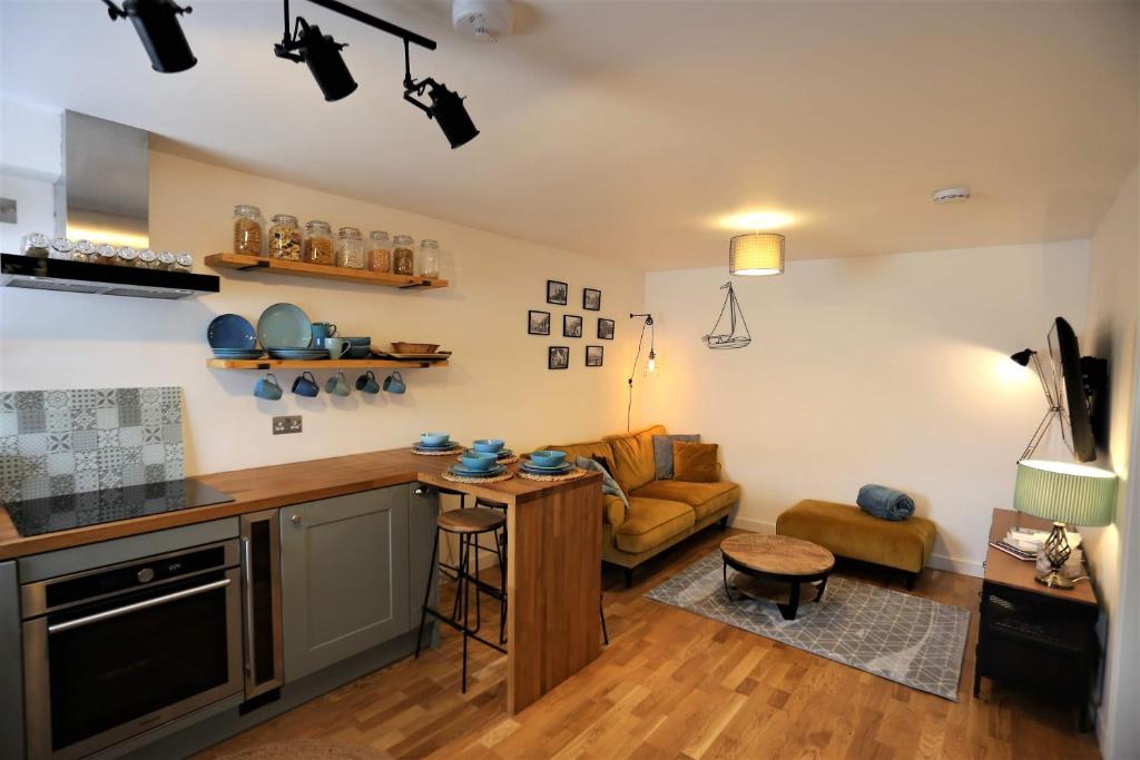 Old fisherman's Cottage No 4, free parking في إدنبرة: مطبخ وغرفة معيشة مع أريكة وطاولة