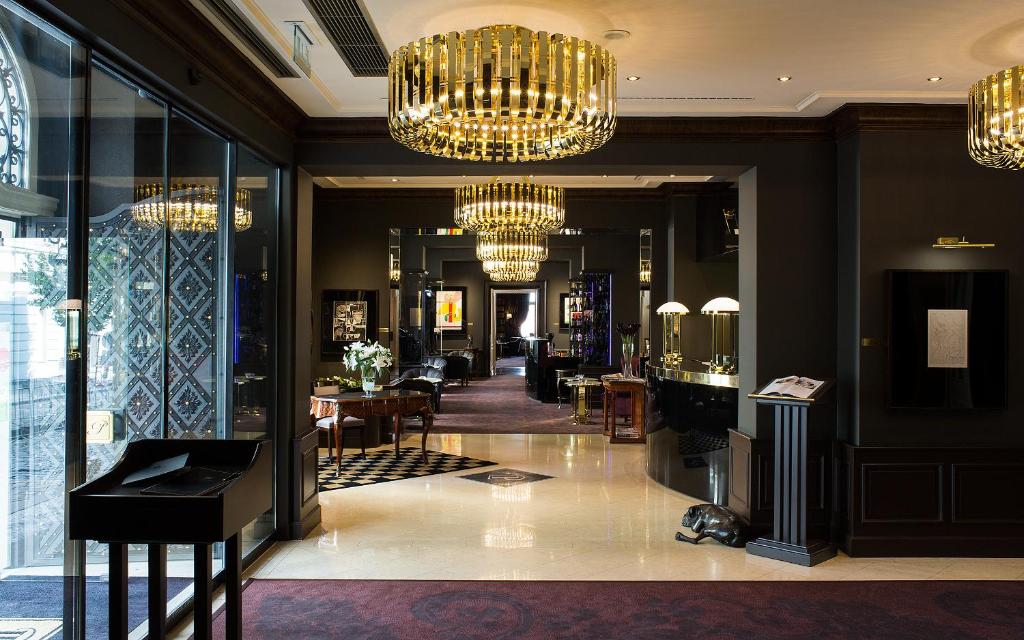a lobby with chandeliers and tables in a store at Le Palais Art Hotel Prague in Prague