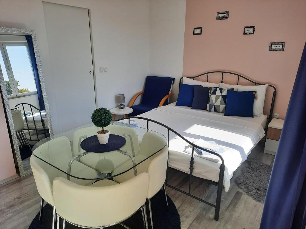 een slaapkamer met een bed en een tafel en stoelen bij Studio apartment S&N in Dubrovnik