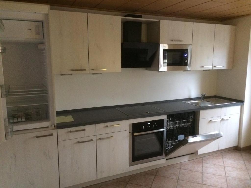 a kitchen with white cabinets and a black counter top at Guesthouse Elbsandstein App. Bastei in Rathmannsdorf
