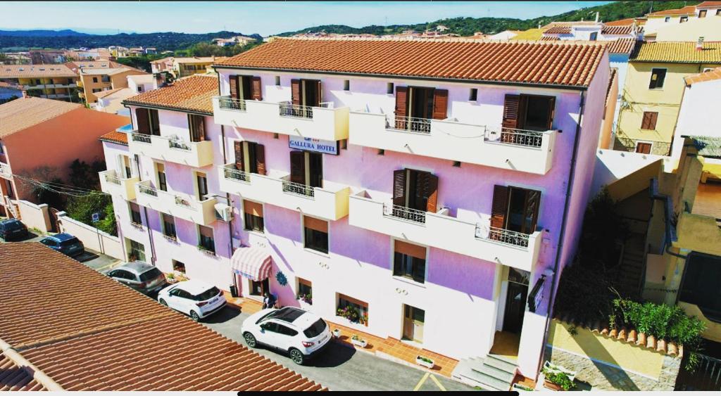 a large building with cars parked in front of it at Gallura Hotel in Santa Teresa Gallura