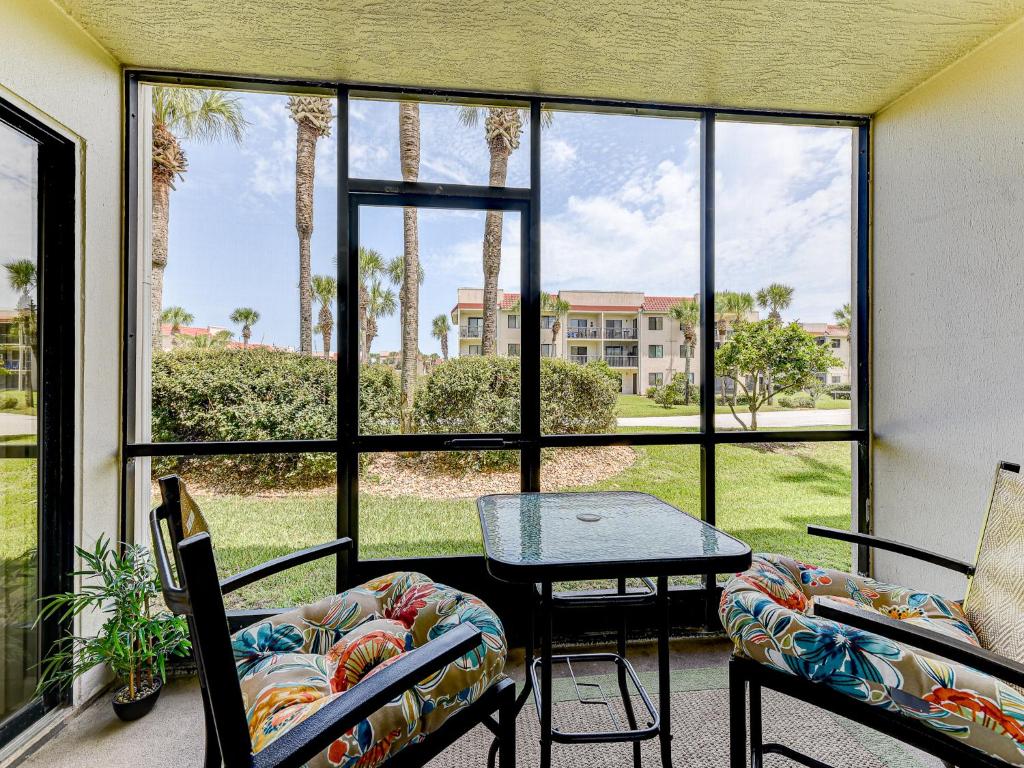 a screened in porch with a table and chairs at Ocean Village Club N16, 1 Bedroom, Sleeps 4, Heated Pool, WiFi in St. Augustine