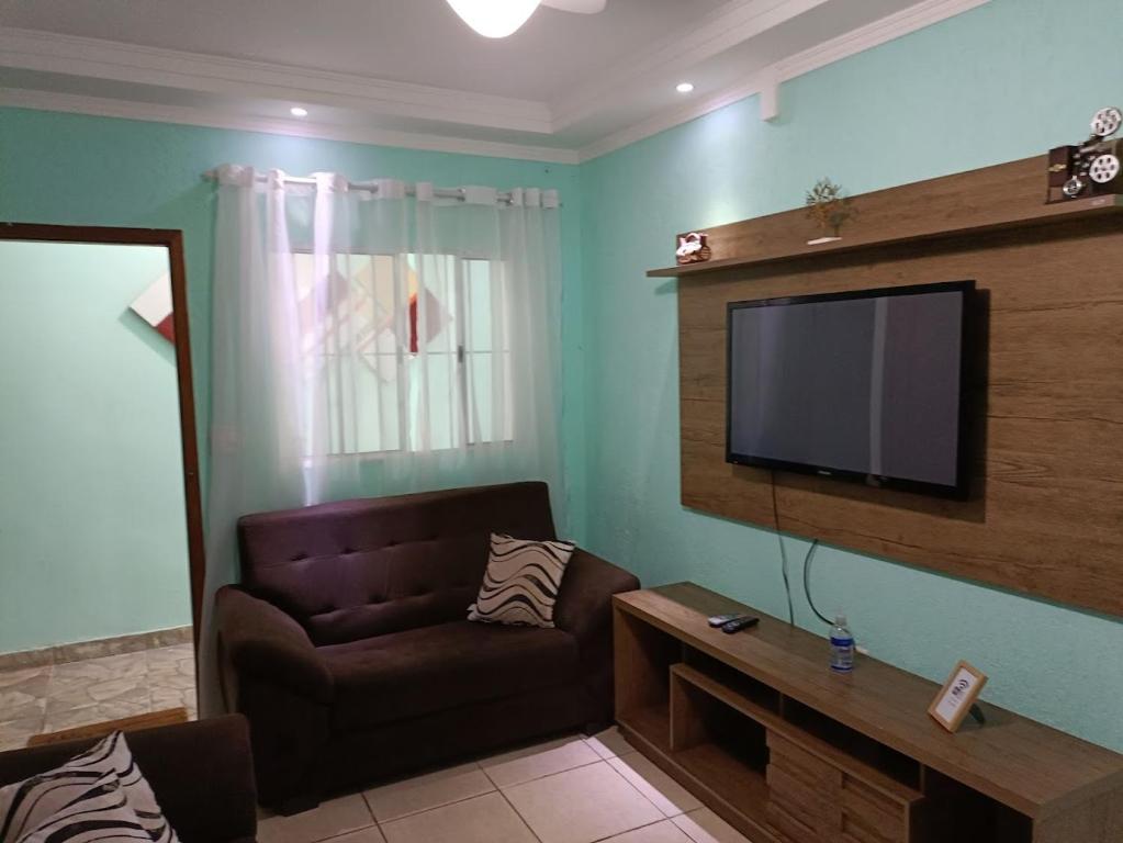 ein Wohnzimmer mit einem Sofa und einem Flachbild-TV in der Unterkunft 10 MIN AEROPORTO GUARULHOS in Guarulhos