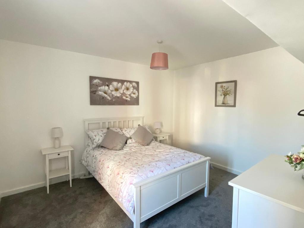 a bedroom with a white bed with pillows on it at Hodge Bower Holidays, Ironbridge - Blakemore in Ironbridge