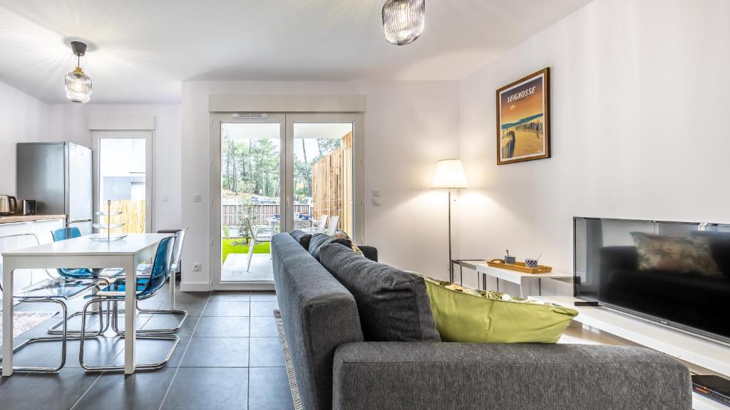 un salon avec un canapé et une table dans l'établissement Magnifique villa 4 pers à 10 min de la plage à pied, à Seignosse