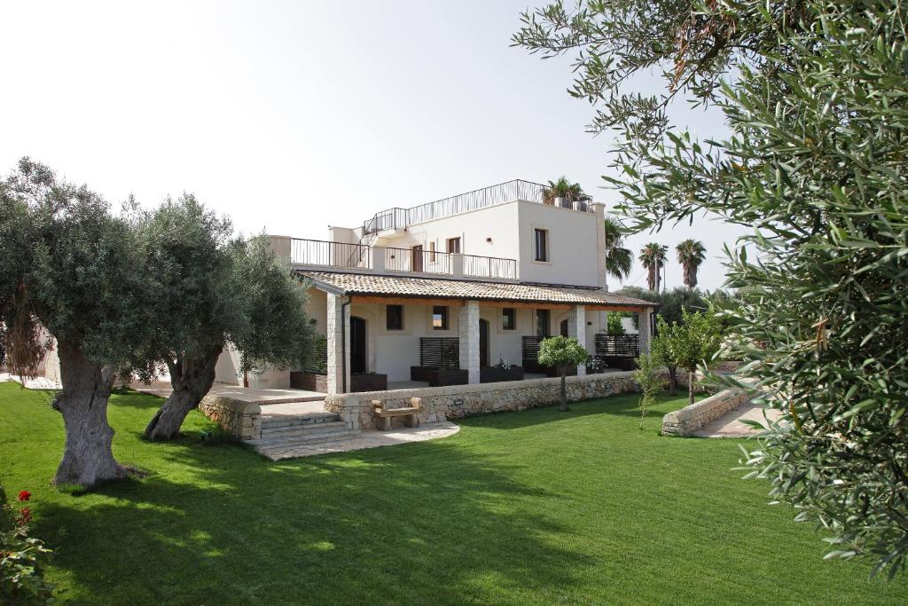 a large white house with a green yard at Casal Sikelio in Cassibile