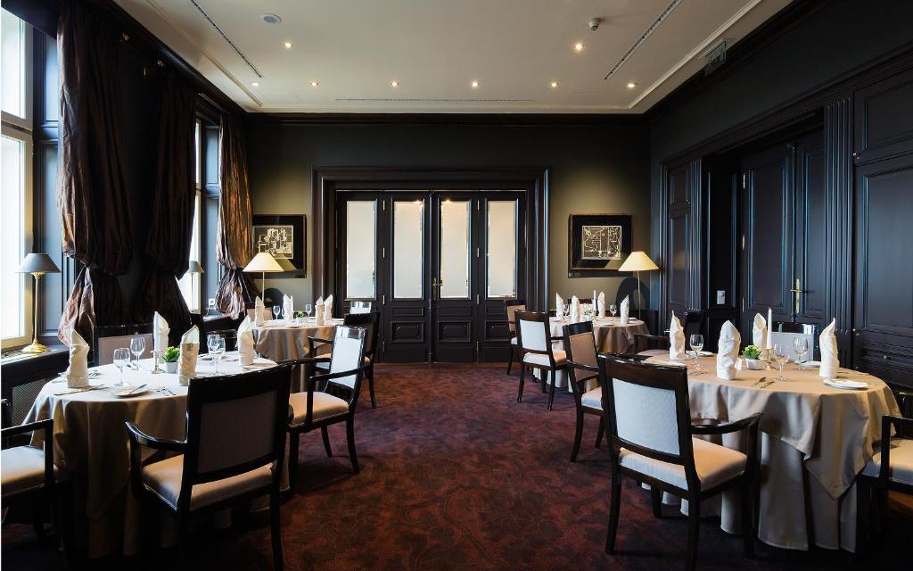 a dining room with tables and chairs in a room at Le Palais Art Hotel Prague in Prague