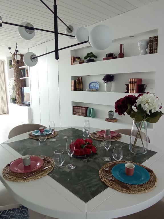 una mesa de comedor con platos y vasos. en Senhora da Guia Boutique Apartment en Vila do Conde