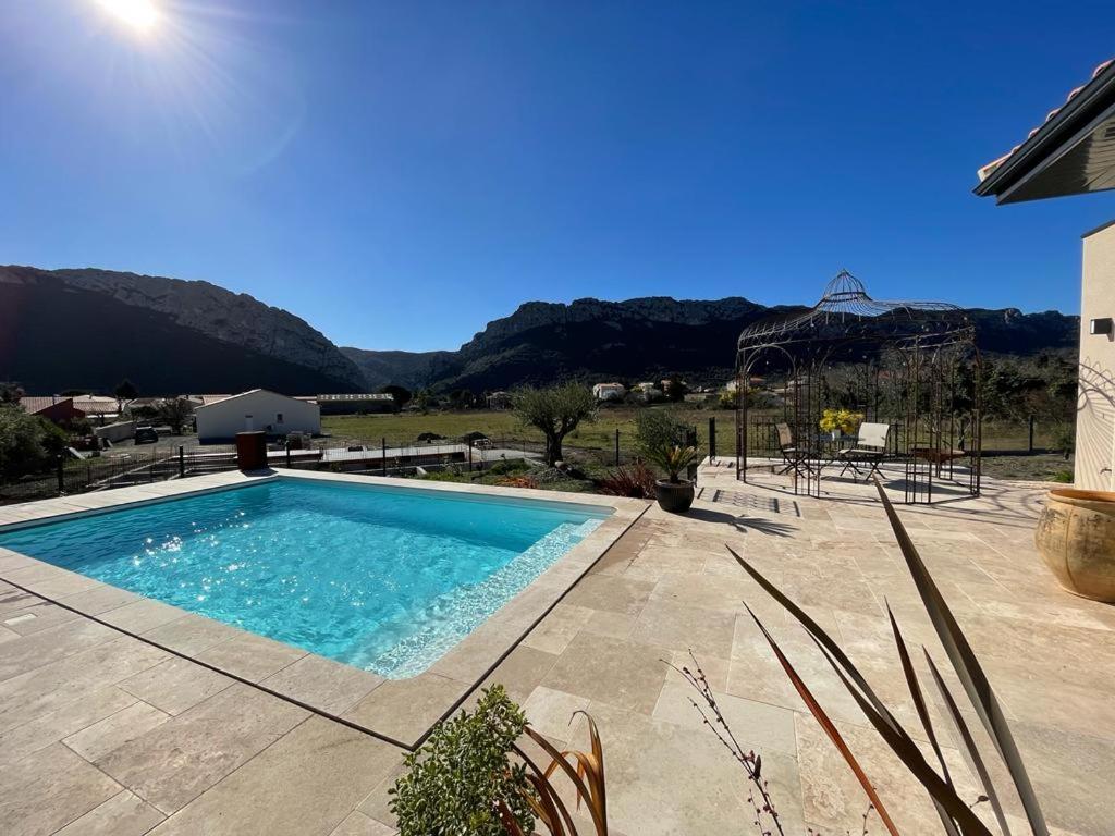 a swimming pool in front of a house with mountains at Domaine Mas Terra in Saint-Paul-de-Fenouillet