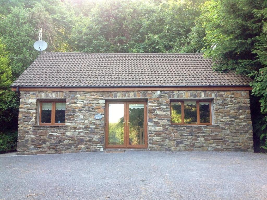 een klein stenen gebouw met twee ramen aan de voorkant bij Little Glebe Cottage in Durrus