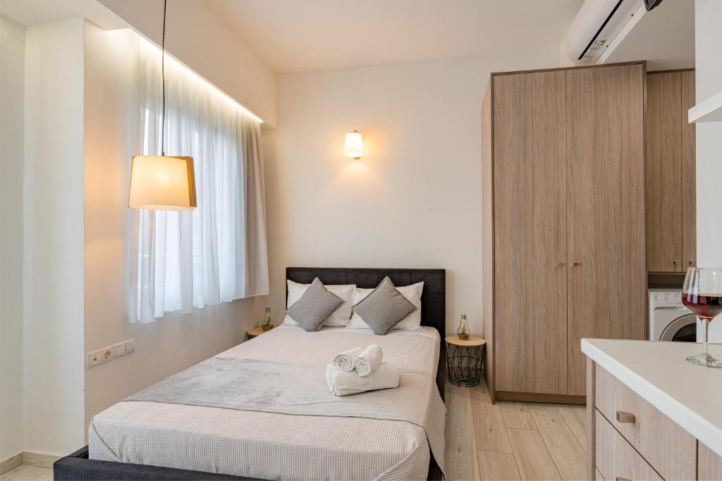1 dormitorio con 1 cama y lavamanos en una habitación en White & Gray apartment, en Rethymno