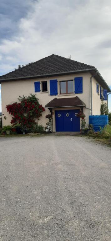 a white and blue house with a blue garage at Guiguitte in La Chapelle-lès-Luxeuil