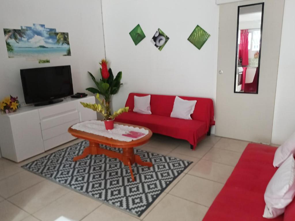- un salon avec un canapé rouge et une table dans l'établissement VILLA AU COEUR DE LA MARMITE, à Sainte-Marie