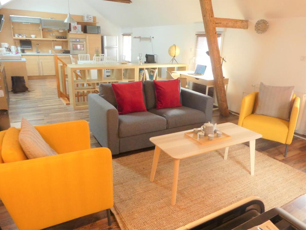 sala de estar con sofá, 2 sillas y mesa en Maison de ville, fibre et Netflix, en Belfort