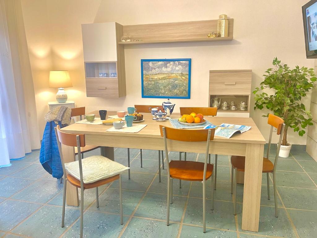 eine Küche mit einem großen Holztisch mit Stühlen in der Unterkunft casa perla in Golfo Aranci