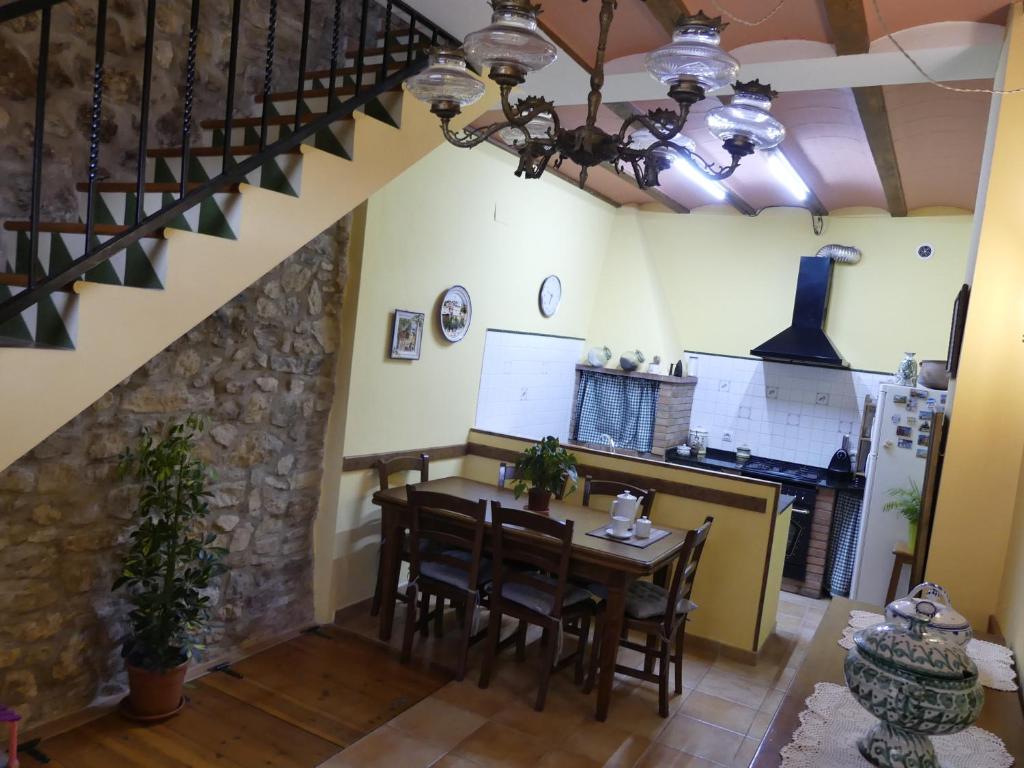 a kitchen and dining room with a table and chairs at Cal Pedrellar in Colldejou