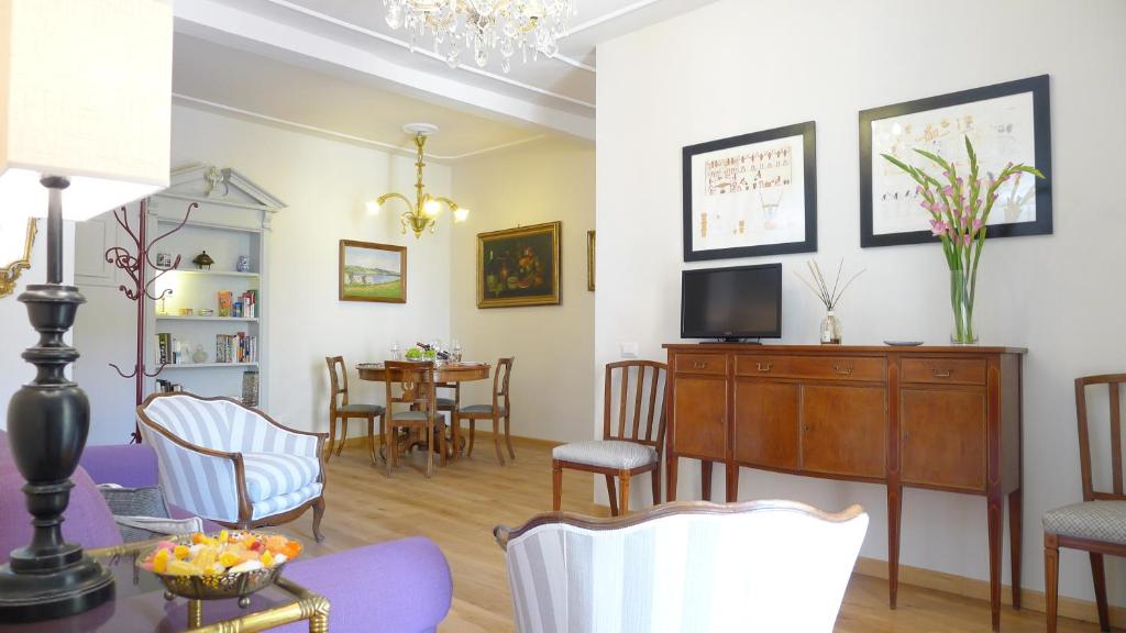 a living room with a table and chairs and a television at Arlecchino in Florence