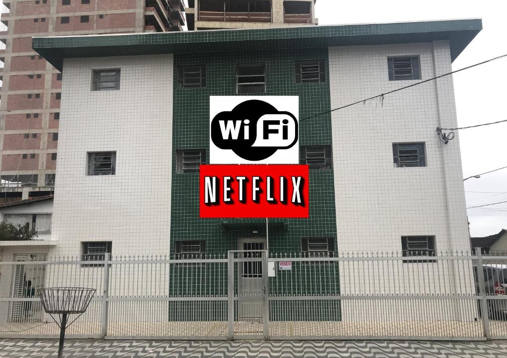 a building with a wfc netflix sign on it at Kit Net Santa Cruz in Praia Grande