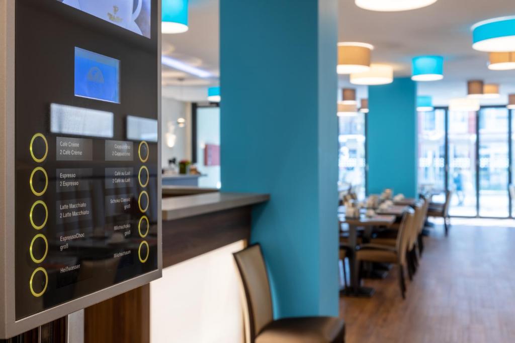 ein Restaurant mit Bar und ein Esszimmer mit Tischen in der Unterkunft Trip Inn Hotel Münster City in Münster