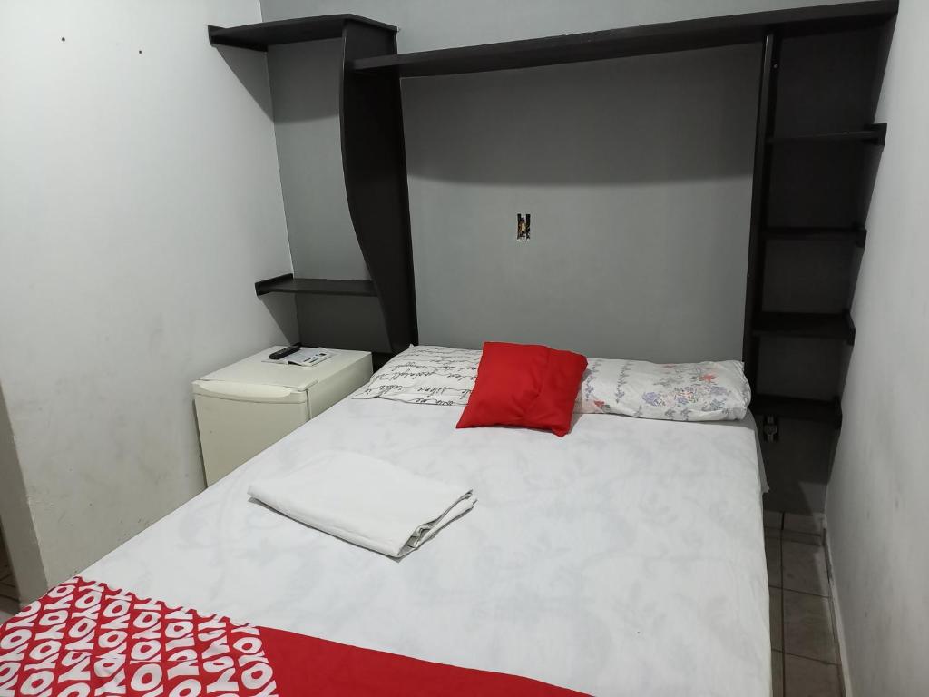 a small bedroom with a bed with red and white sheets at Noite hotel in Palmas