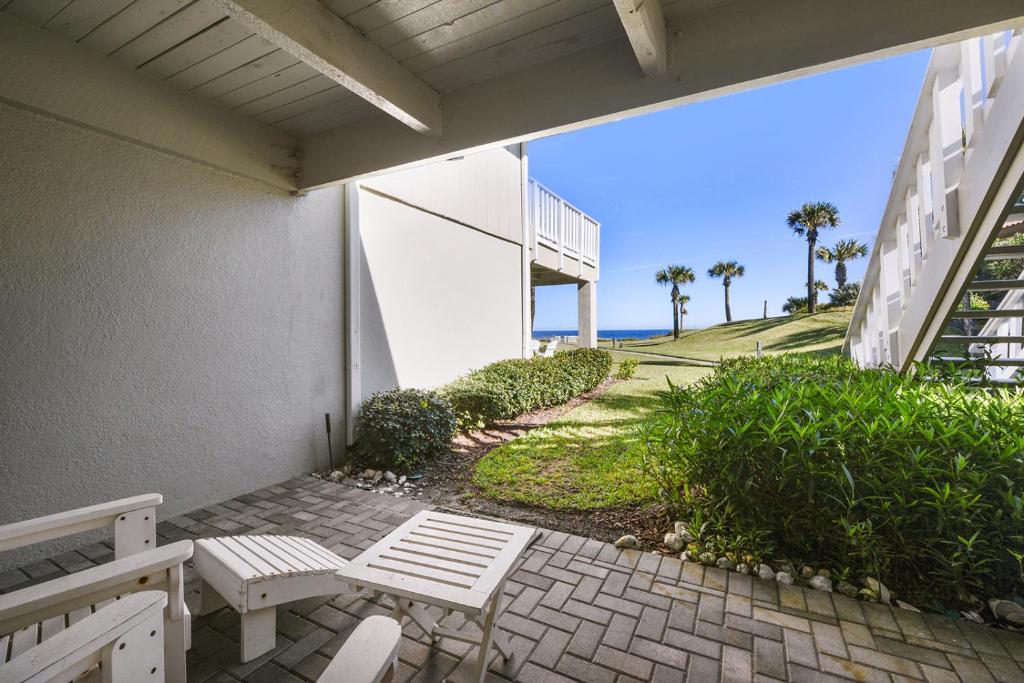 a patio with two white benches and the ocean at Surf Villa 626, 1 Bedroom, Beach Front, WiFi, Sleeps 4 in Ponte Vedra