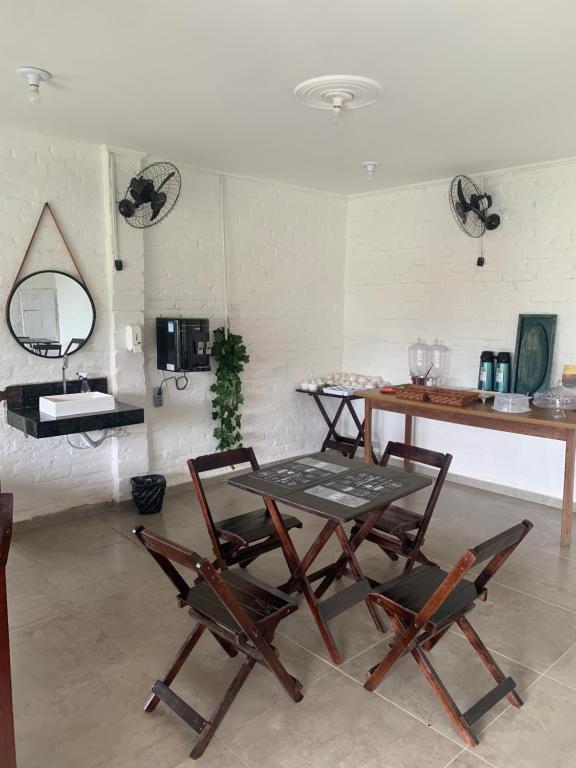 einen Tisch und Stühle in einem Zimmer mit Waschbecken in der Unterkunft Hotel Colonial Suites ,Bracel, Lwart, Zilor in Lençóis Paulista