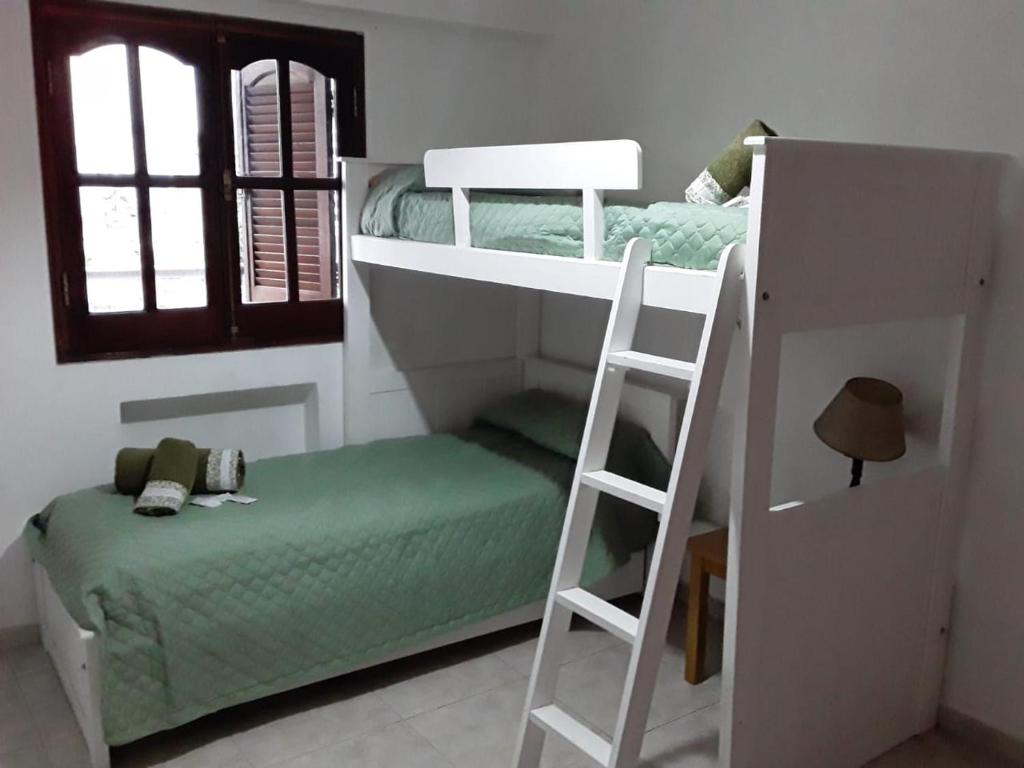 a bedroom with two bunk beds and a ladder at Altos de Santiago Bed & Breakfast in San Miguel de Tucumán
