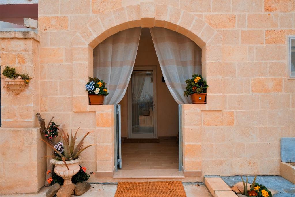 an entrance to a brick building with two potted plants at Villa Sette Nani in Torre Lapillo