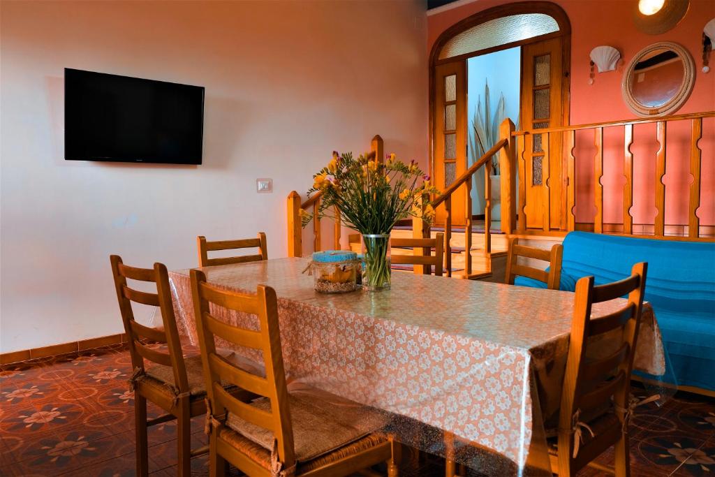a dining room table with a vase of flowers on it at Villa Sette Nani in Torre Lapillo