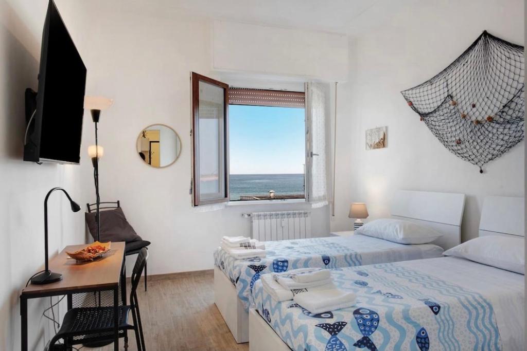 une chambre avec deux lits et un bureau et une fenêtre dans l'établissement Happy Home, à Savone