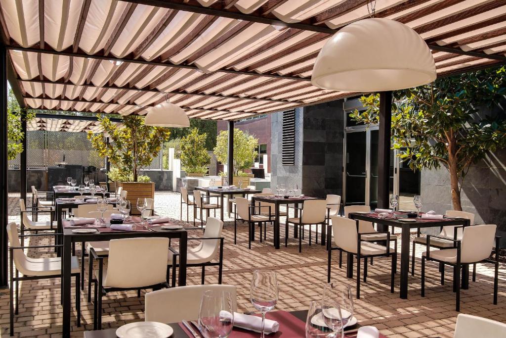 a restaurant with tables and chairs on a patio at PCM Forum Alcalá in Alcalá de Henares