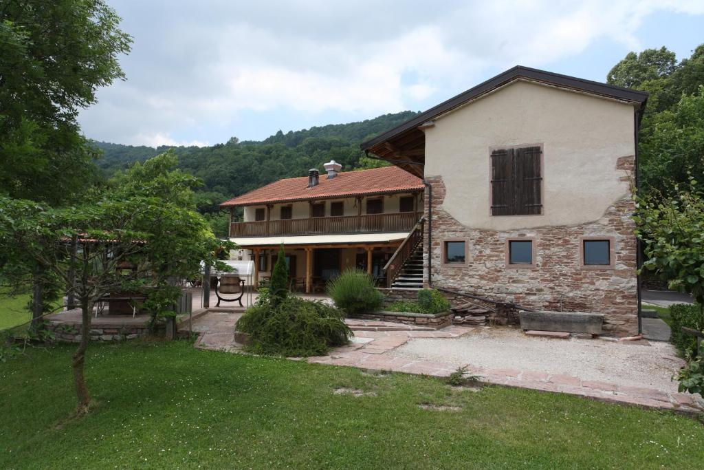 a large house with a yard and a building at Agriturismo Cornolade in Ponte nellʼAlpi