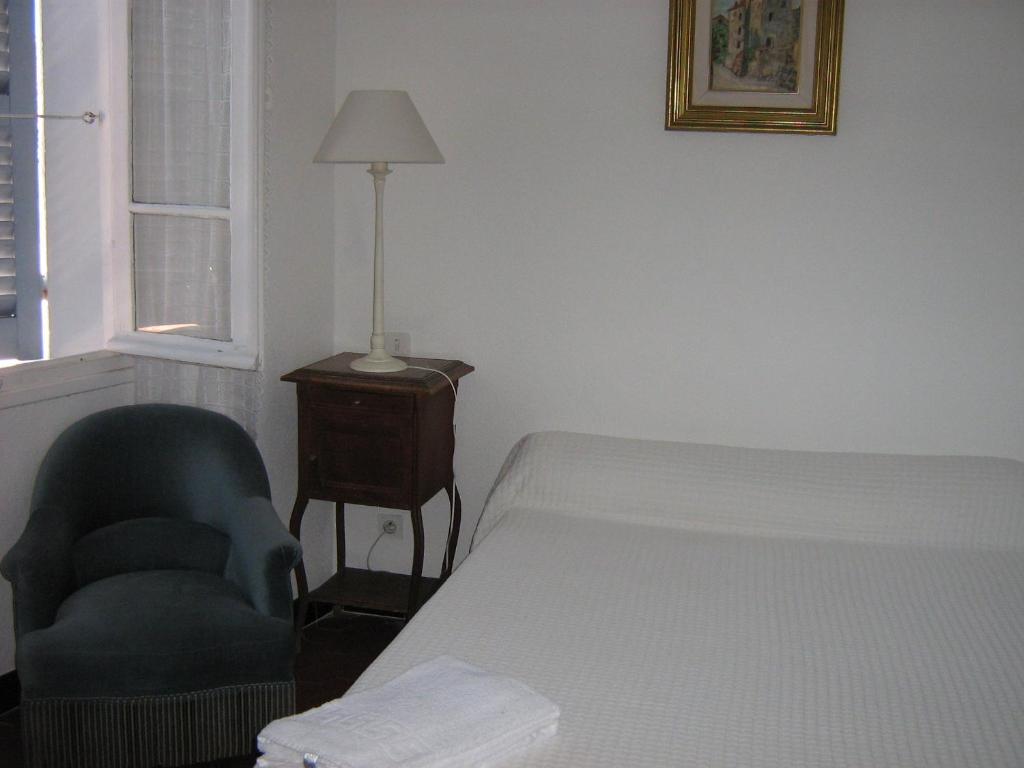 ピアナにあるMaison d'hôtes San Pedruのベッドルーム1室(ベッド1台、椅子、ランプ付)