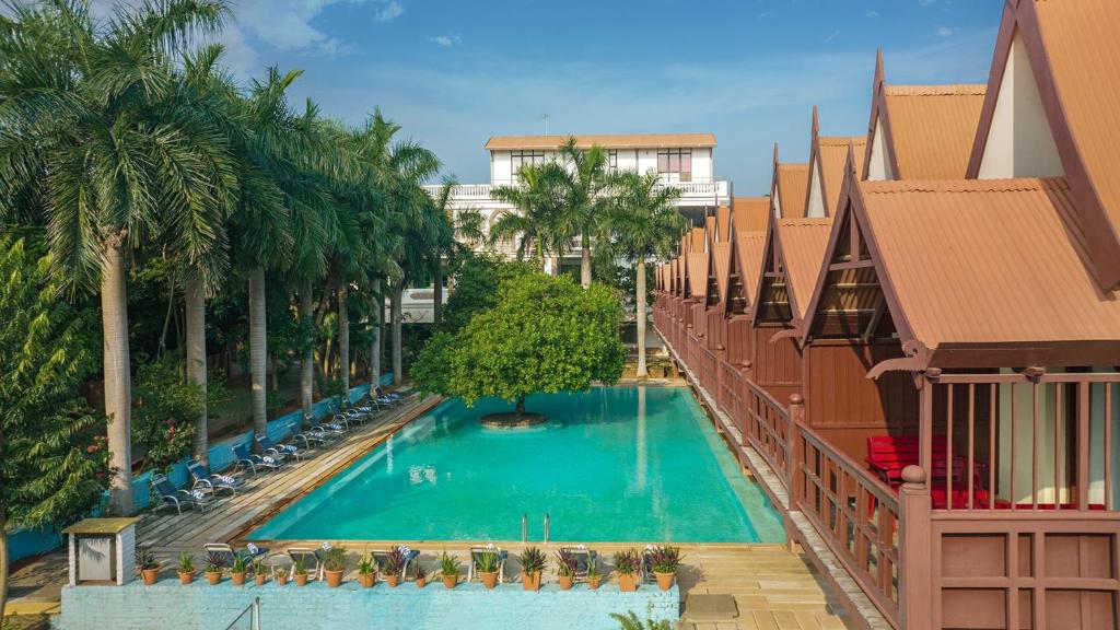 an overhead view of a swimming pool with palm trees at Mango Hill Pondicherry in Pondicherry