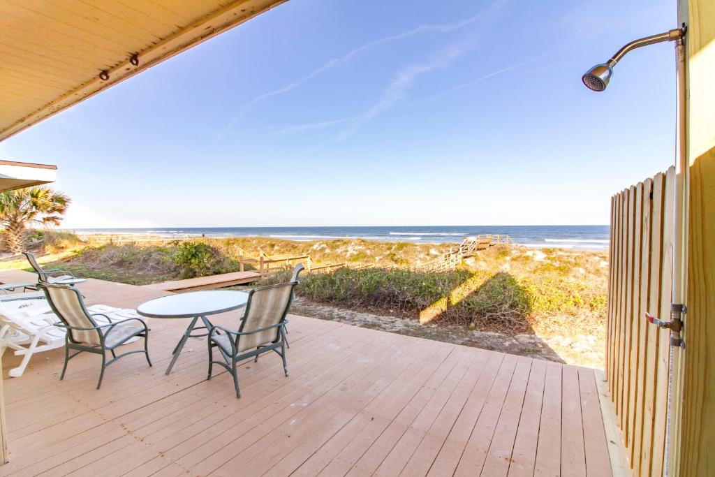 a patio with a table and chairs and the beach at Hunter's Haven, 2 Bedrooms, Sleeps 6, Ocean Front, Pet Friendly in Crescent Beach