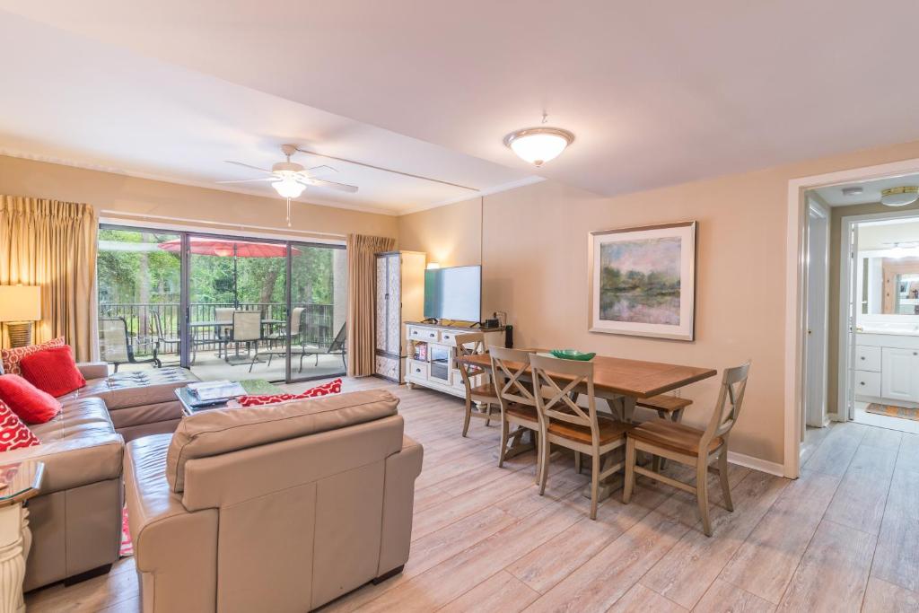 a living room with a couch and a table and chairs at Village House 102 in Hilton Head Island