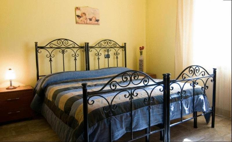 een zwart bed met een blauw dekbed in een slaapkamer bij B&B Mare Nostrum in Catona