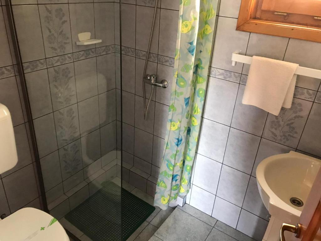 uma casa de banho com um chuveiro, um WC e um lavatório. em Manó Kulcsosházak em Praid