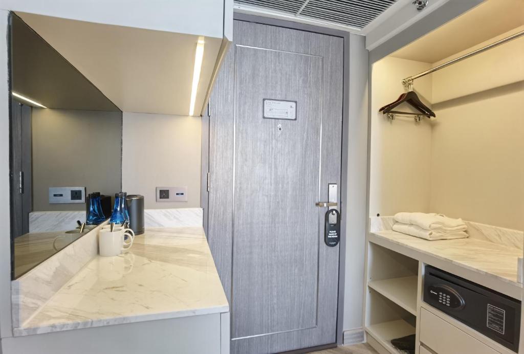 A compact entry area with a refreshment counter, open wardrobe and safe.