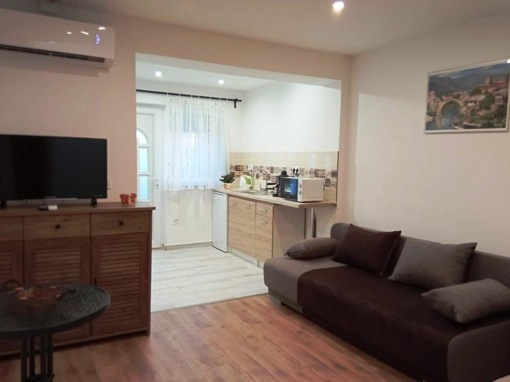 uma sala de estar com um sofá e uma cozinha em Érdi Muskátlis Vendégház em Érd