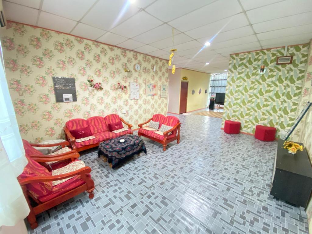 a living room with red chairs and a table at VIE HOMESTAY TAWAU in Tawau