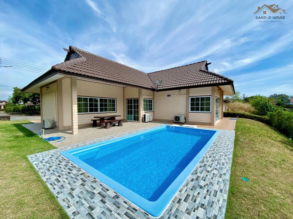 a villa with a swimming pool in front of a house at Sand-D House Pool Villa A15 at Rock Garden Beach Resort Rayong in Mae Pim