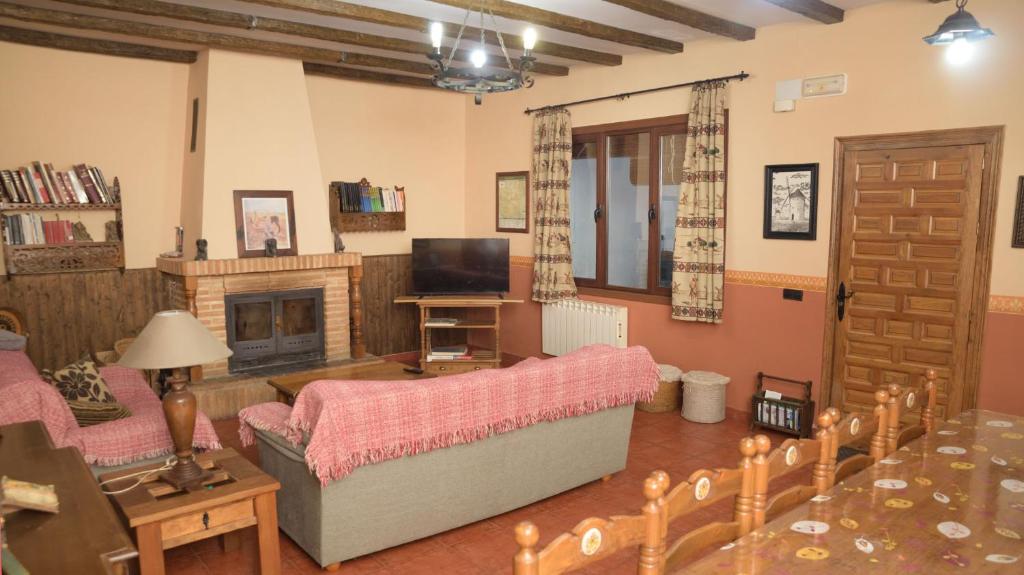 sala de estar con sofá y chimenea en CASA RURAL QUIJOTE Y SANCHO en Argamasilla de Alba