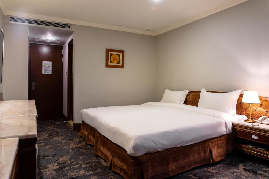 a hotel room with a large bed and a desk at Chiayi King Hotel in Chiayi City