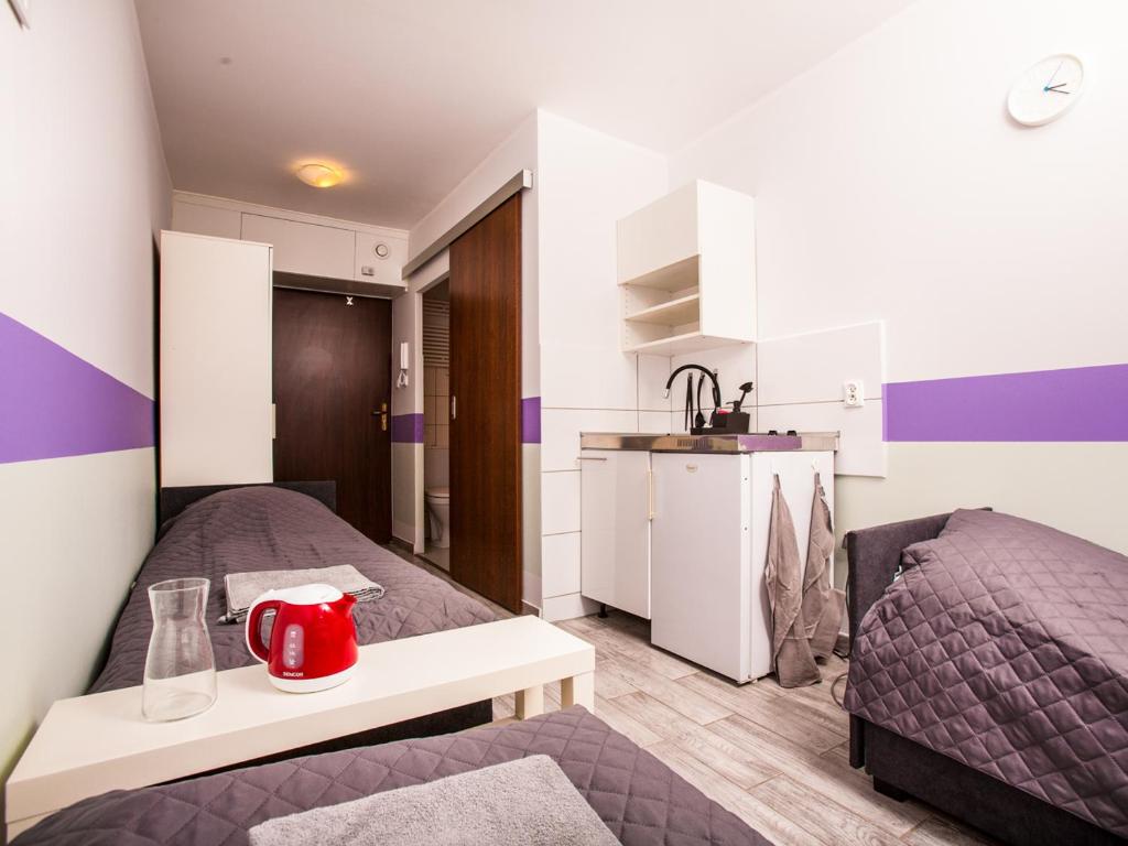 mały pokój z 2 łóżkami i kuchnią w obiekcie SUDO studios we Wrocławiu