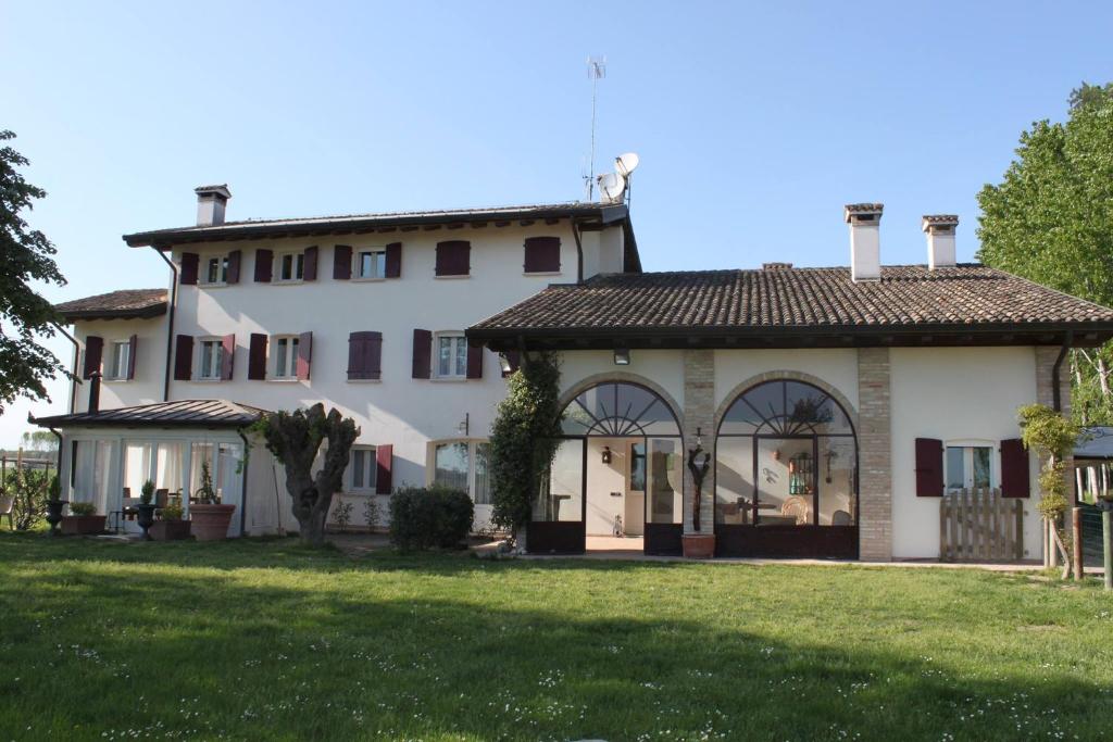 a large white house with a large yard at B&B Casa del Bosco in San Michele al Tagliamento