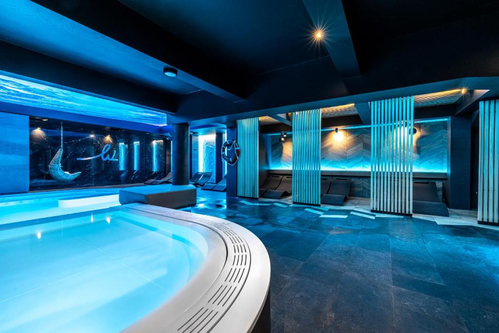 an indoor pool in a house with blue lighting at Hotel Warszawa Spa & Resort in Augustów